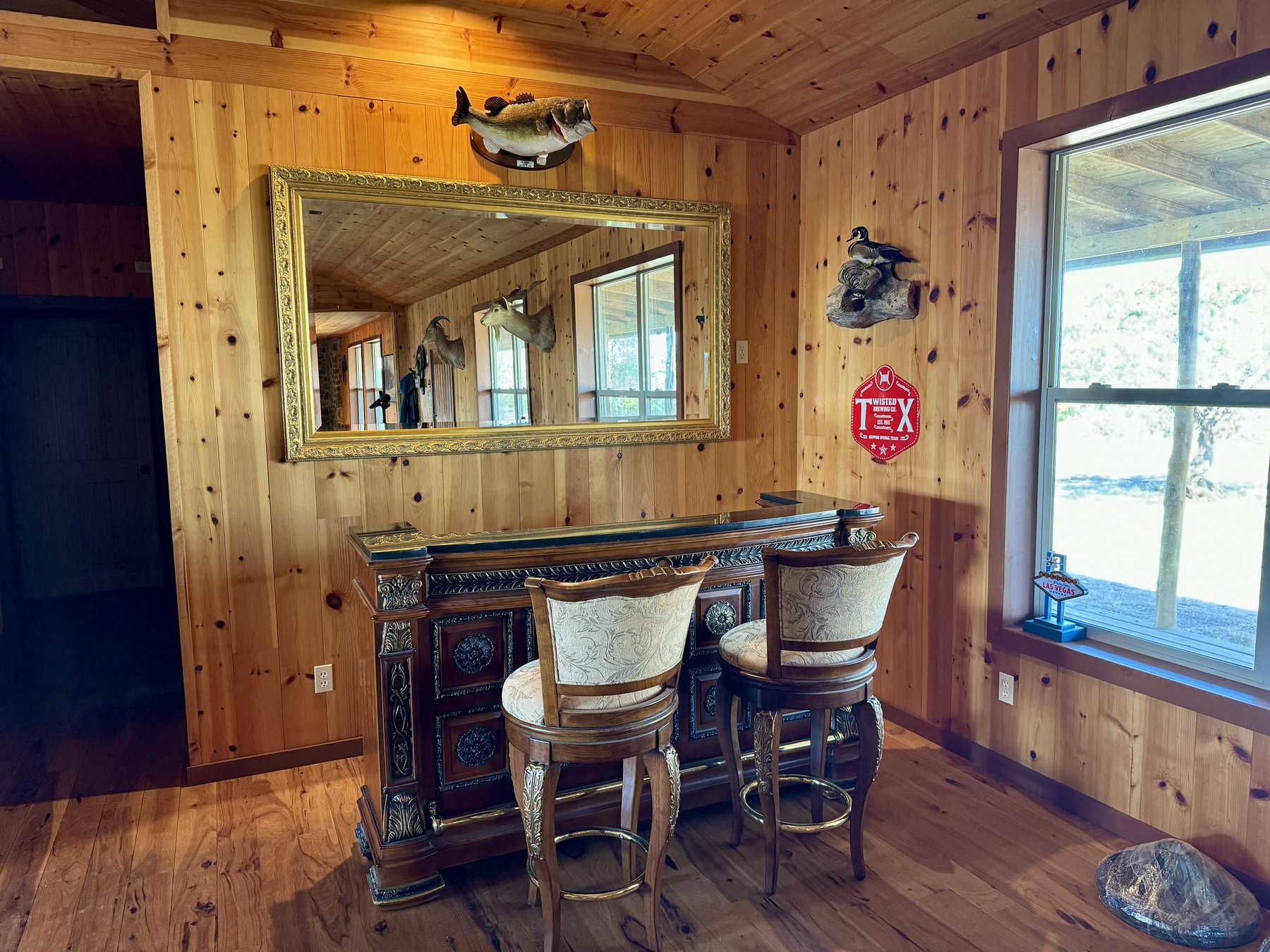 3-Wire Ranch interior bar room — knotty pine walls, ornate bar, mounted trophy fish