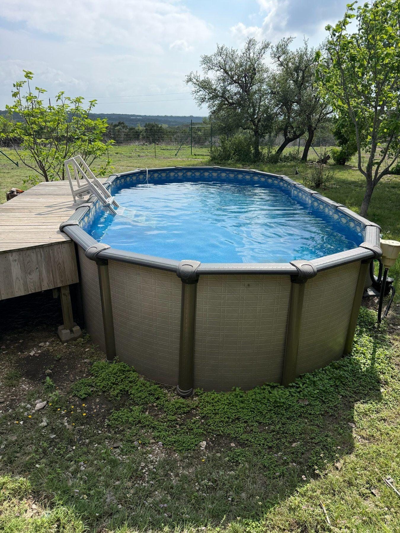 3-Wire Ranch pool with Hill Country views — above-ground pool with wood deck and open sky